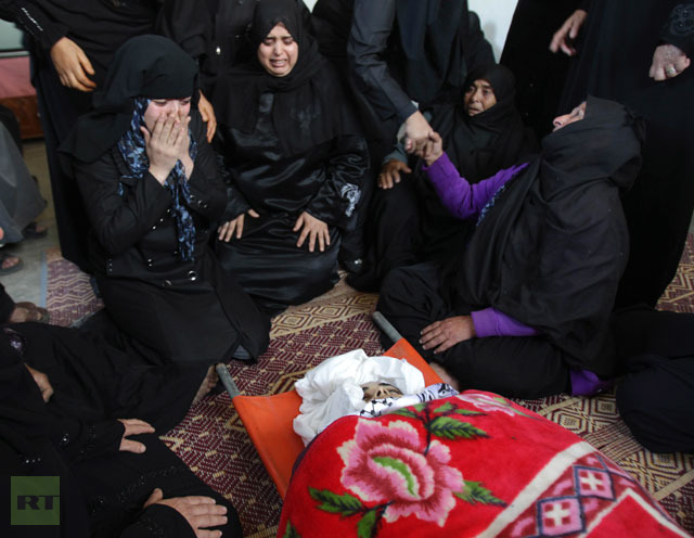 Palestinian relatives of Samaher Gdeeh mourn next to her body during her funeral in Khan Younis in the southern Gaza Strip.(Reuters / Ibraheem Abu Mustafa)